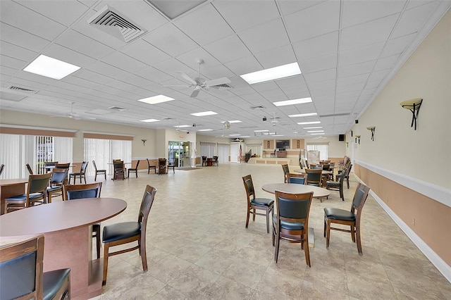 dining space featuring ceiling fan and a drop ceiling