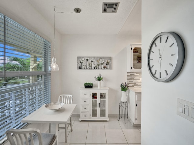 tiled dining area featuring a textured ceiling