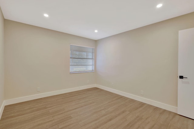 empty room featuring recessed lighting, light wood-style flooring, and baseboards