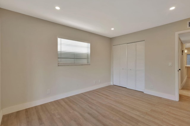 unfurnished bedroom with light wood finished floors, recessed lighting, a closet, visible vents, and baseboards