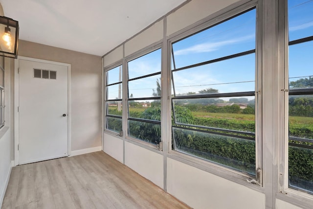 interior space featuring visible vents, light wood-style flooring, and baseboards