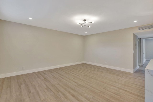 unfurnished room featuring baseboards, visible vents, and light wood finished floors