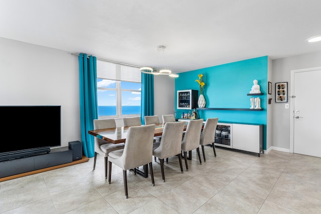 dining room featuring an inviting chandelier and a water view