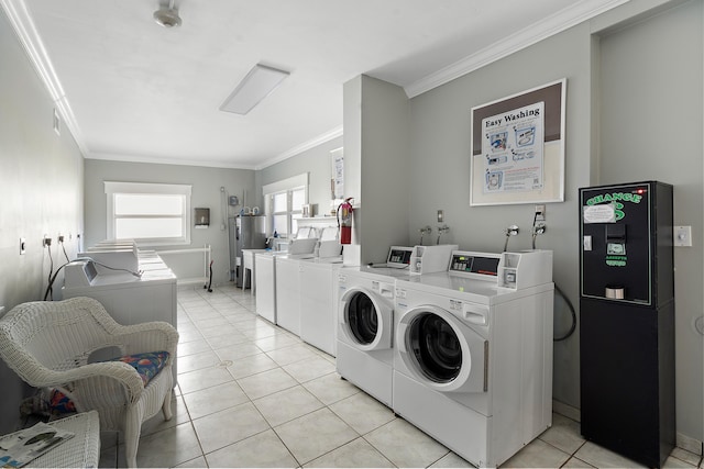 washroom with ornamental molding, separate washer and dryer, and light tile patterned floors