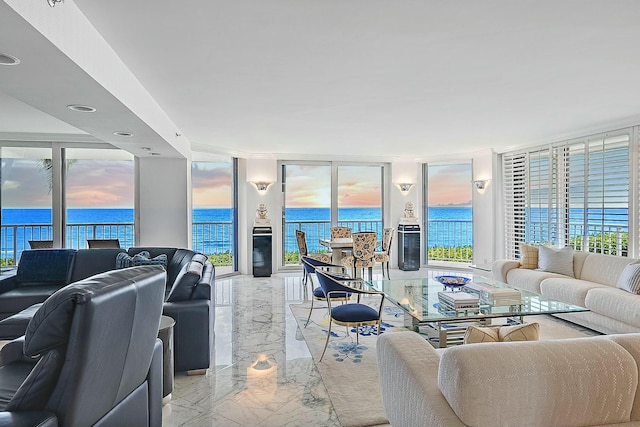 living room with a water view, marble finish floor, plenty of natural light, and a wall of windows