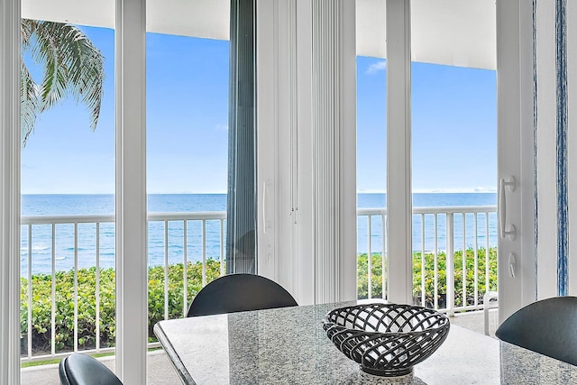 dining area featuring a water view and a wealth of natural light