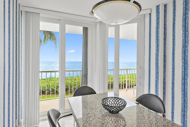 dining area featuring a wealth of natural light and a water view