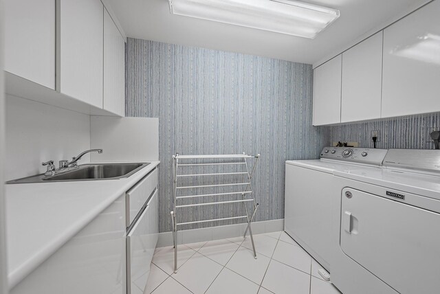 laundry area with separate washer and dryer, sink, light tile patterned floors, and cabinets