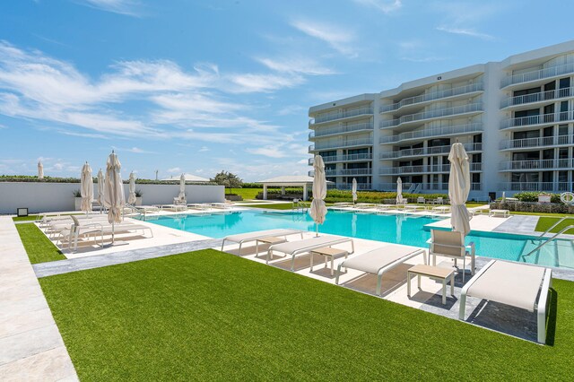 pool with a patio area and a water view