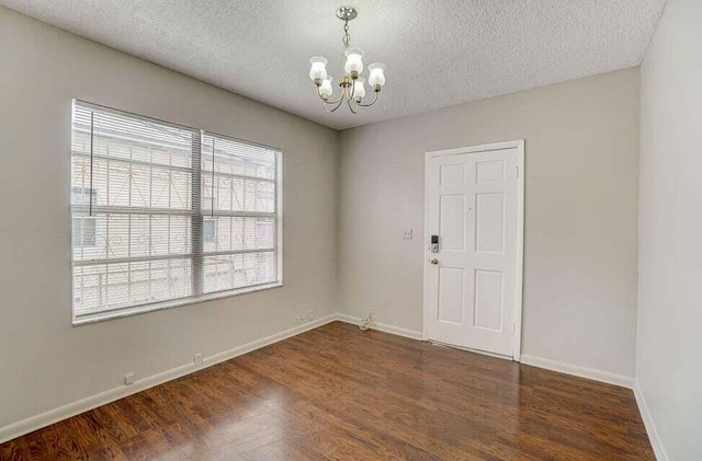 2511 W Abdella St, Tampa, FL 33607 - empty room with dark wood-type flooring, a notable chandelier, and a textured ceiling