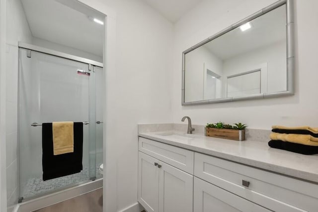 bathroom with vanity, toilet, wood-type flooring, and an enclosed shower