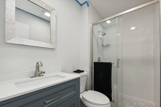 bathroom featuring toilet, an enclosed shower, and vanity