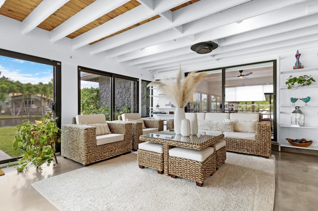 sunroom / solarium featuring beamed ceiling, ceiling fan, a healthy amount of sunlight, and wooden ceiling