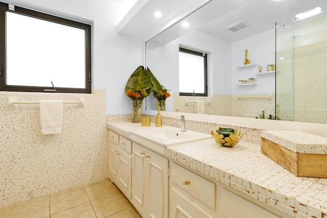 bathroom with tile patterned flooring, vanity, and tile walls