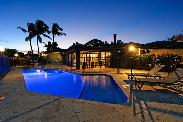 pool at dusk featuring a patio