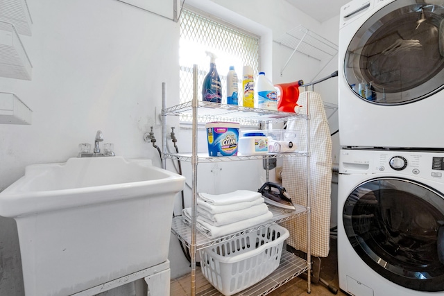 laundry area featuring stacked washer / drying machine and sink