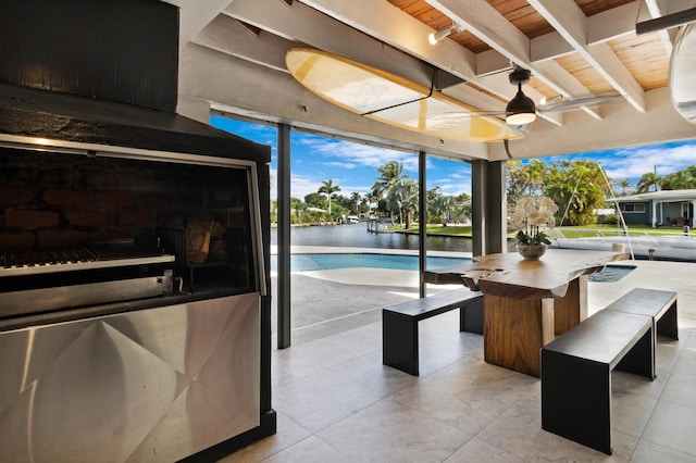 view of patio with a water view and ceiling fan