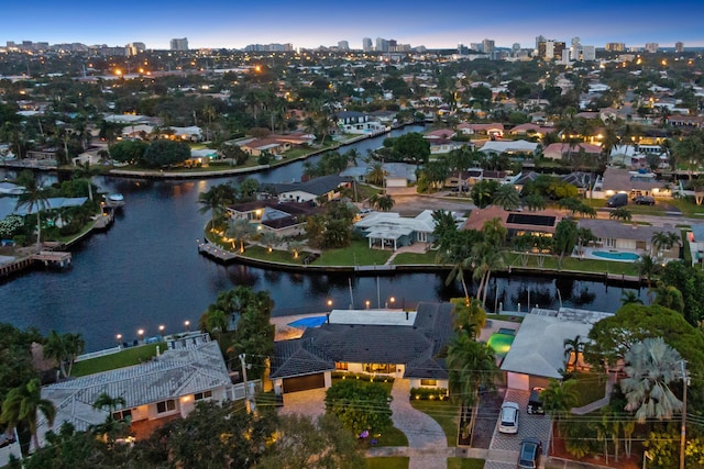 aerial view at dusk featuring a water view