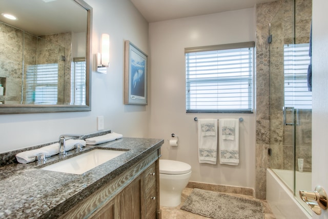 full bathroom featuring toilet, bath / shower combo with glass door, vanity, and tile patterned floors