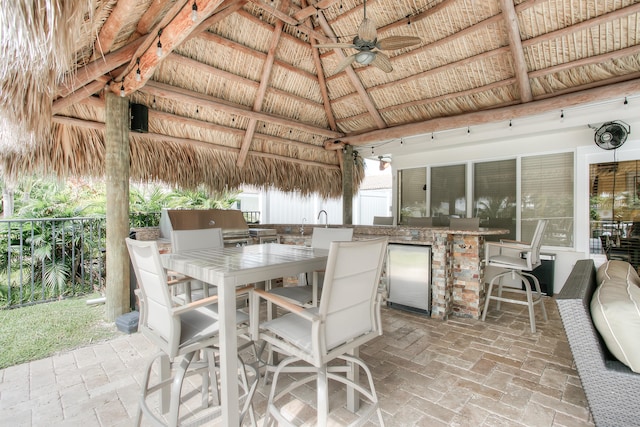 view of patio / terrace featuring a gazebo, ceiling fan, area for grilling, and a bar