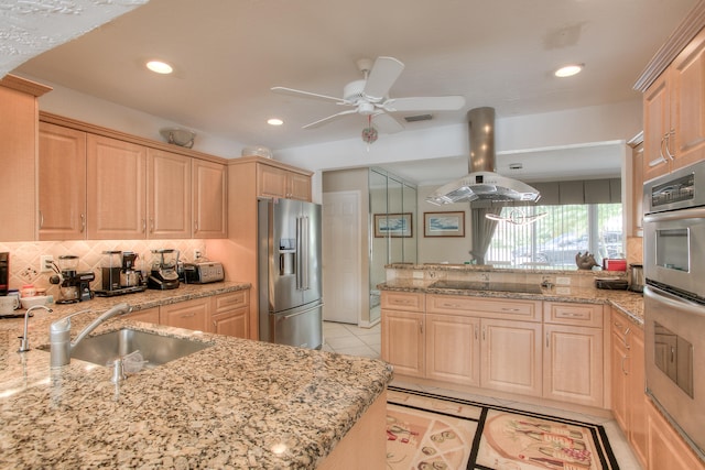 kitchen featuring light brown cabinetry, island exhaust hood, light stone countertops, and stainless steel appliances