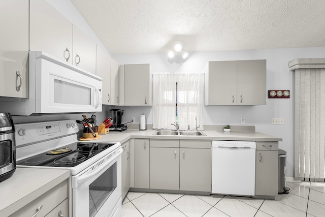 kitchen featuring light tile patterned flooring, a textured ceiling, sink, and white appliances