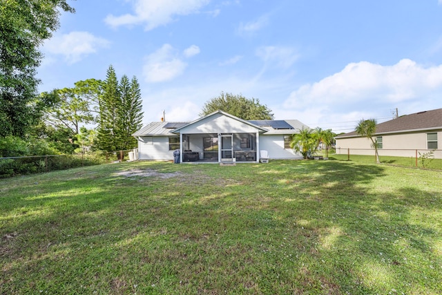 rear view of property featuring a lawn and a sunroom