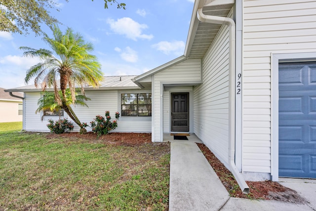 doorway to property with a lawn