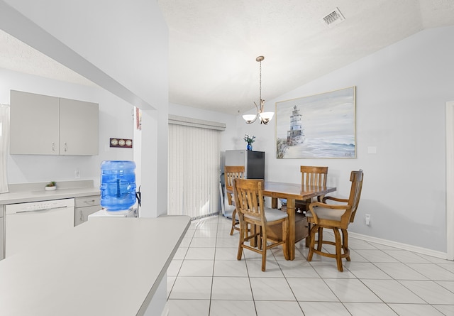 tiled dining area featuring a textured ceiling, vaulted ceiling, and an inviting chandelier