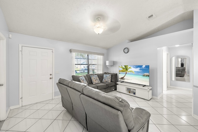 living room with light tile patterned floors, a textured ceiling, vaulted ceiling, and ceiling fan