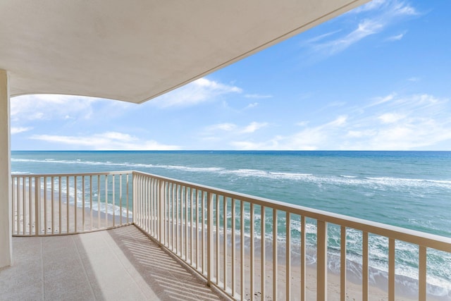 balcony featuring a view of the beach and a water view