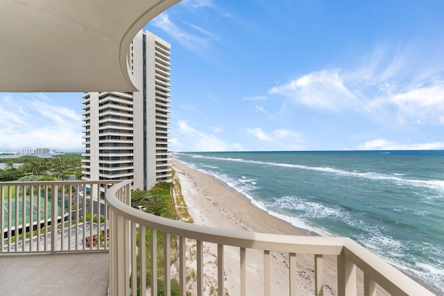 balcony featuring a water view and a beach view