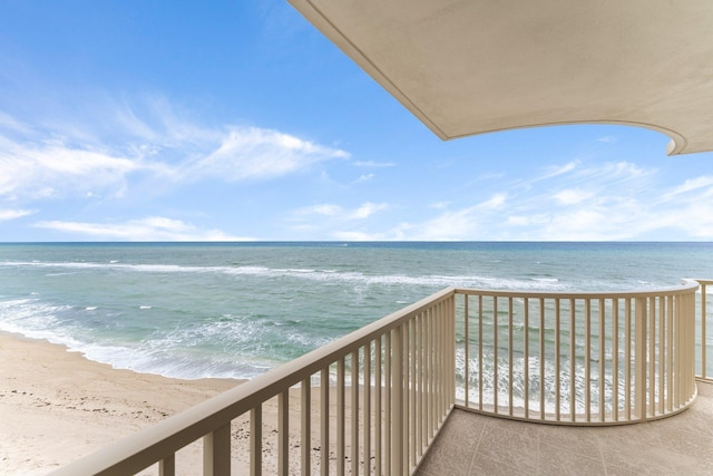 balcony featuring a beach view and a water view