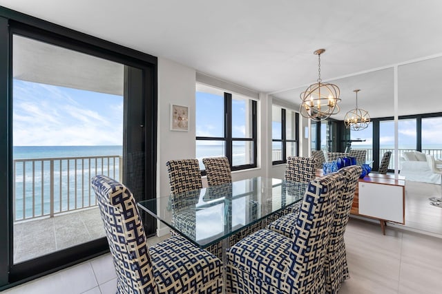 dining area featuring a chandelier, a water view, floor to ceiling windows, and a healthy amount of sunlight