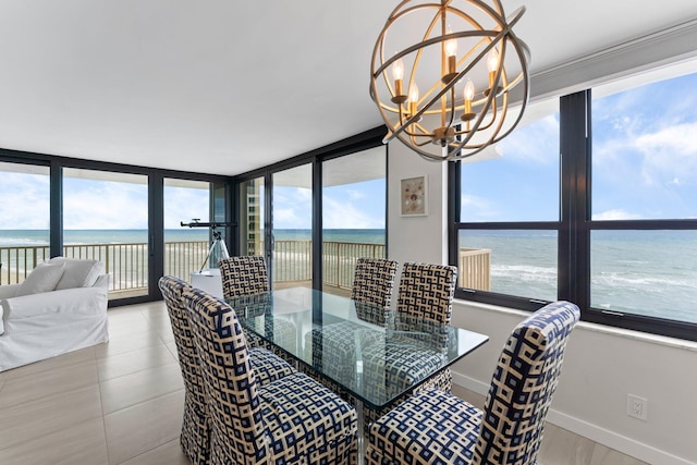 tiled dining room featuring a wealth of natural light, a water view, and a chandelier