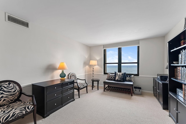 sitting room with light carpet and a water view