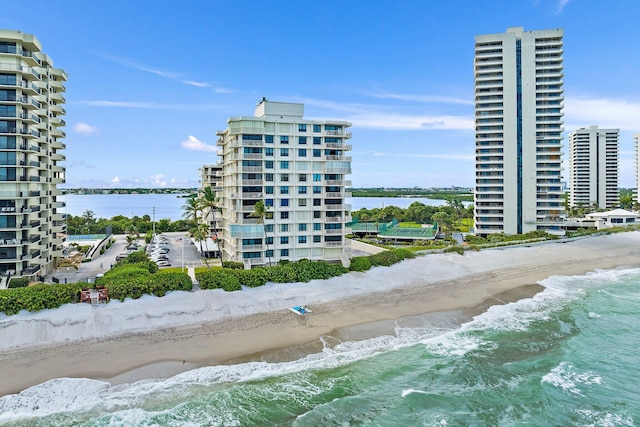 view of property with a water view and a beach view