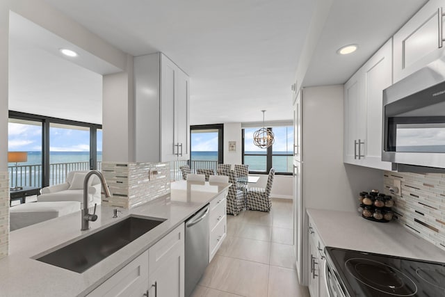 kitchen with sink, a water view, white cabinetry, and stainless steel appliances