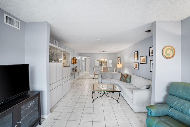 tiled living room featuring a chandelier and a textured ceiling