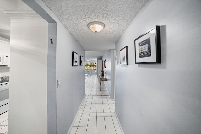 hallway with light tile patterned floors and a textured ceiling