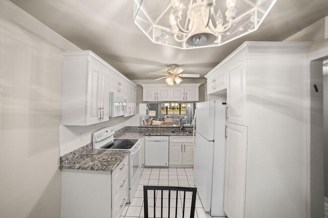 kitchen with ceiling fan with notable chandelier, white appliances, light tile patterned floors, decorative light fixtures, and white cabinetry