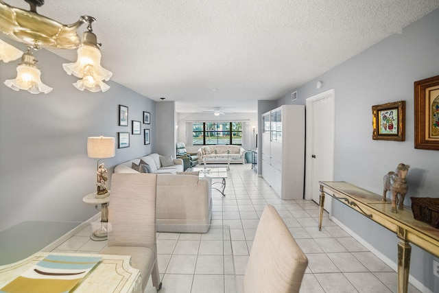 living room featuring ceiling fan, light tile patterned floors, and a textured ceiling