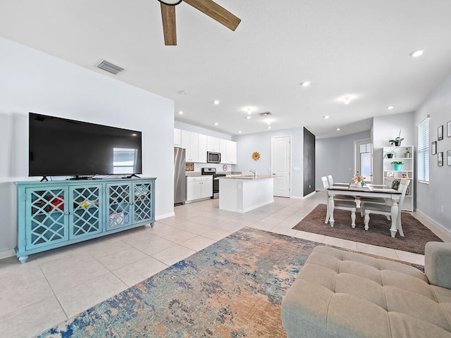 living room featuring ceiling fan and light tile patterned floors