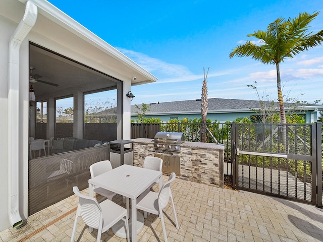 view of patio / terrace featuring area for grilling, ceiling fan, and an outdoor kitchen