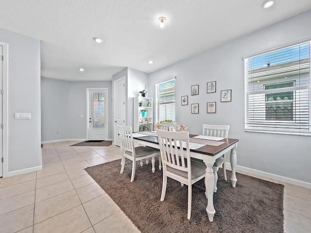 tiled dining area featuring a textured ceiling