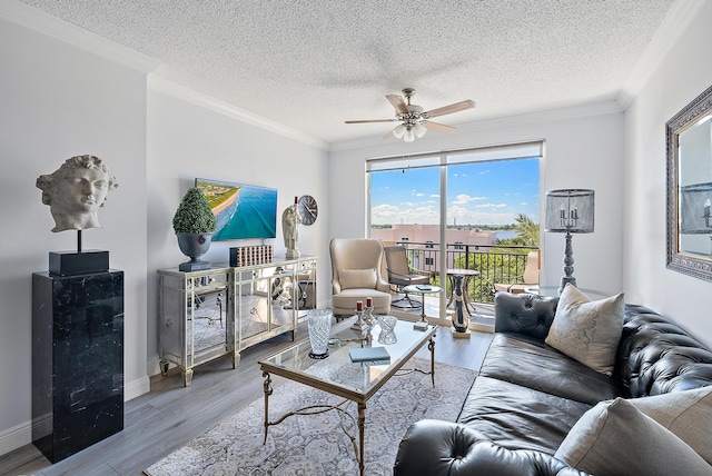 living room featuring light hardwood / wood-style flooring, ornamental molding, and ceiling fan