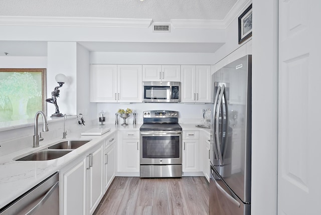 kitchen with stainless steel appliances, a textured ceiling, sink, and white cabinets