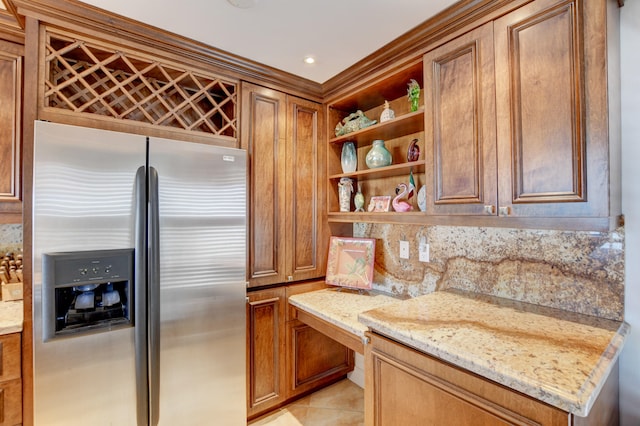 kitchen with stainless steel fridge, light stone countertops, decorative backsplash, and light tile patterned flooring