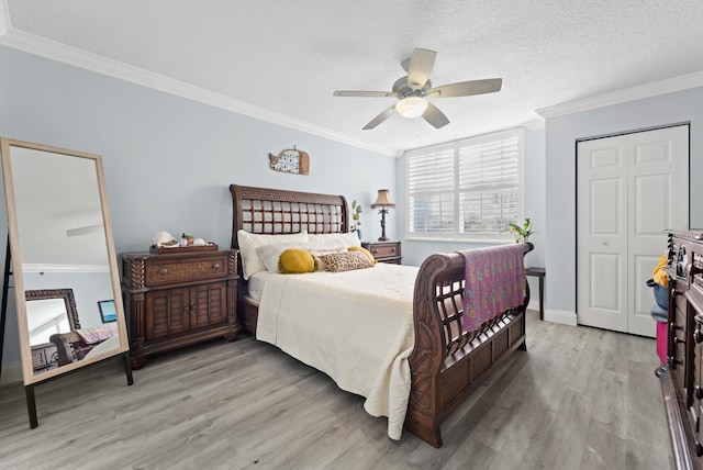 bedroom with ornamental molding, a textured ceiling, ceiling fan, hardwood / wood-style flooring, and a closet