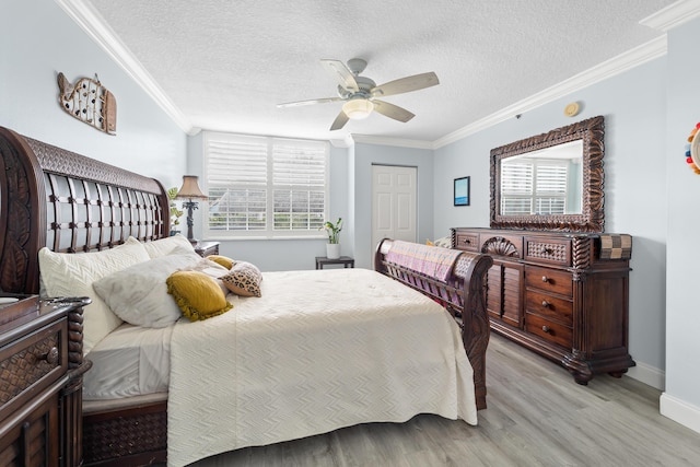 bedroom featuring a textured ceiling, light hardwood / wood-style floors, ceiling fan, and crown molding